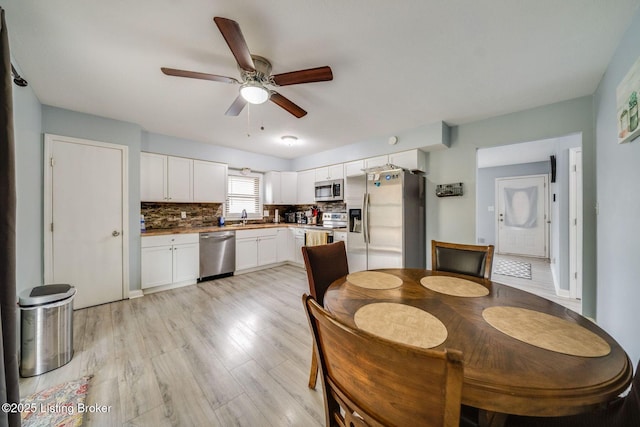 dining area with ceiling fan and light wood-style floors