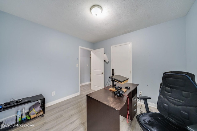 office area featuring baseboards, a textured ceiling, and light wood-style floors