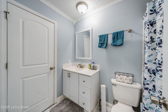 bathroom with baseboards, toilet, ornamental molding, a textured ceiling, and vanity