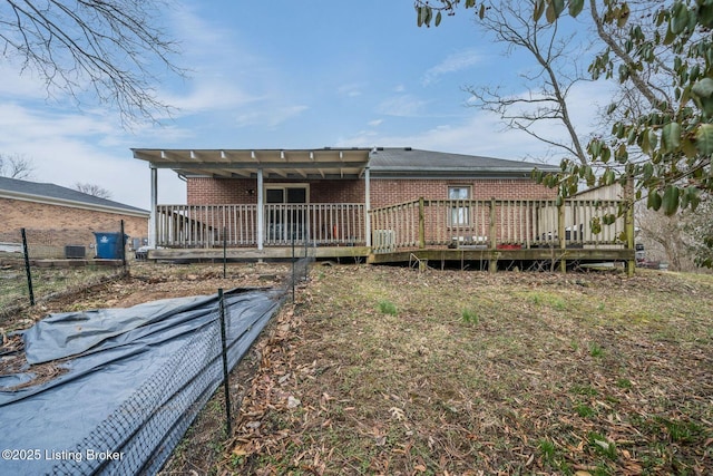 rear view of house with brick siding and a wooden deck