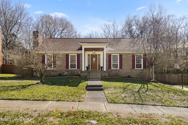 view of front of property featuring brick siding, fence, and a front yard