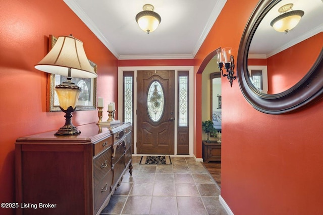 foyer entrance featuring tile patterned flooring, baseboards, arched walkways, and crown molding