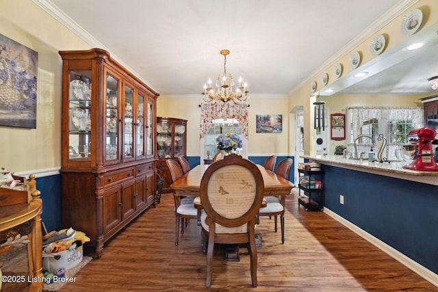 dining area with crown molding, a chandelier, and wood finished floors