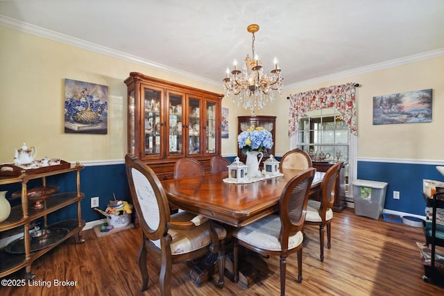 dining room with baseboards, ornamental molding, wood finished floors, and an inviting chandelier