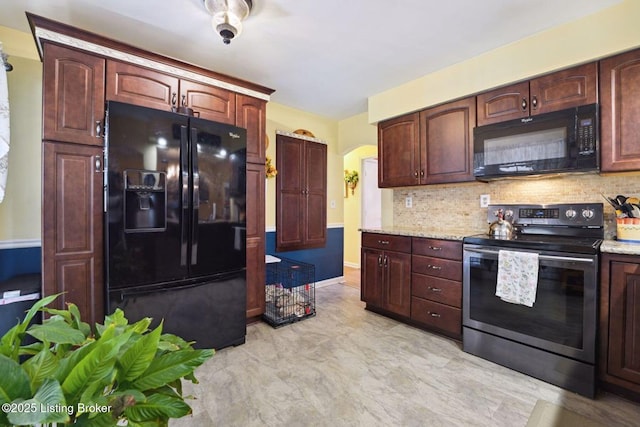 kitchen featuring black appliances, backsplash, light stone countertops, and baseboards