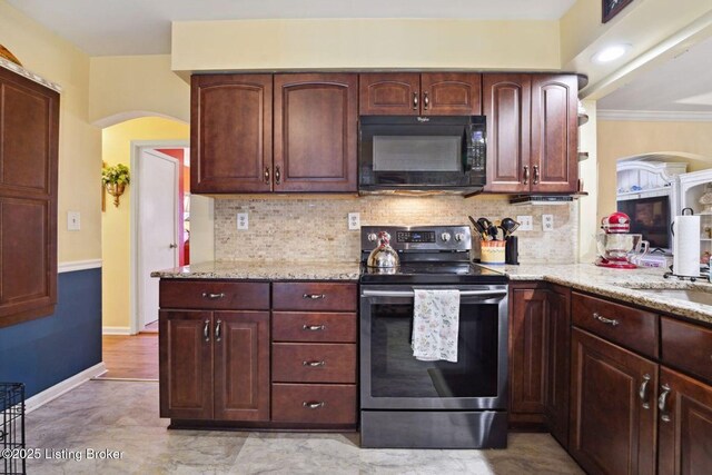 kitchen with black microwave, backsplash, stainless steel range with electric stovetop, and light stone countertops