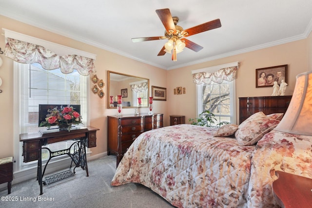 carpeted bedroom with ceiling fan, baseboards, and crown molding