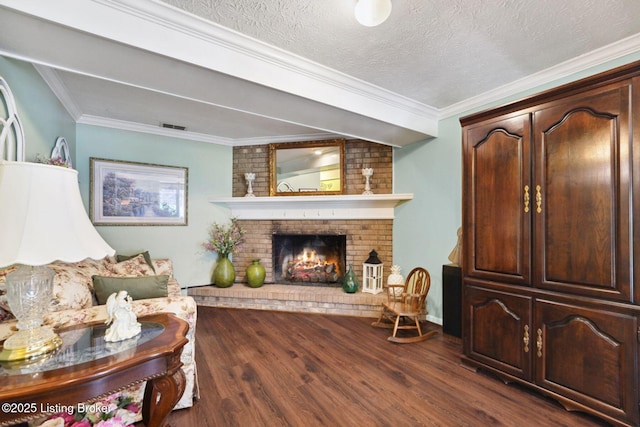 living area featuring visible vents, a fireplace, a textured ceiling, and wood finished floors