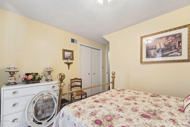 bedroom featuring a textured ceiling, a closet, and visible vents