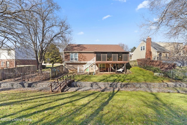 back of property featuring stairs, a yard, fence, and a sunroom