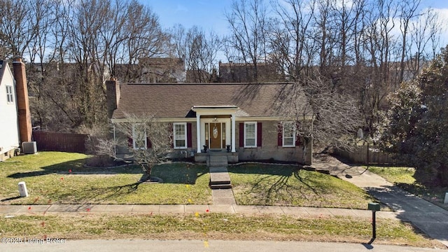 view of front of home with a front yard, roof with shingles, fence, and a chimney