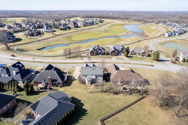 drone / aerial view with a water view, view of golf course, and a residential view