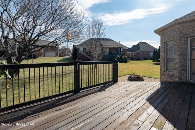 wooden deck featuring an outdoor fire pit and a yard