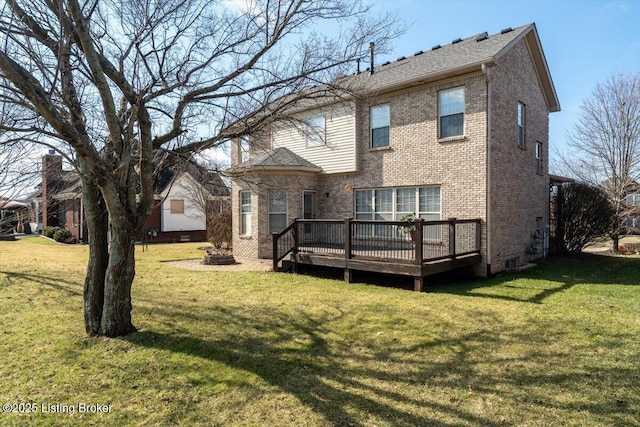 back of property with a yard, a deck, and brick siding