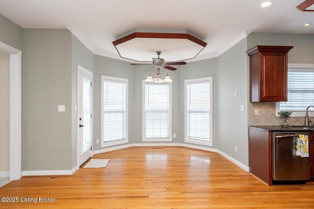 kitchen featuring light wood finished floors, baseboards, decorative backsplash, ornamental molding, and stainless steel dishwasher