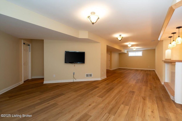 below grade area featuring visible vents, light wood-style flooring, and baseboards