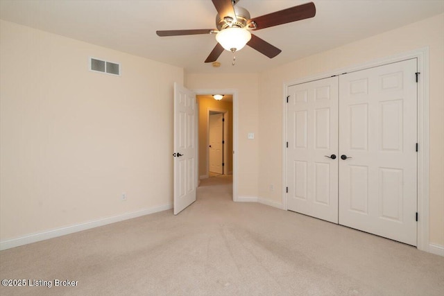 unfurnished bedroom with light carpet, baseboards, visible vents, ceiling fan, and a closet