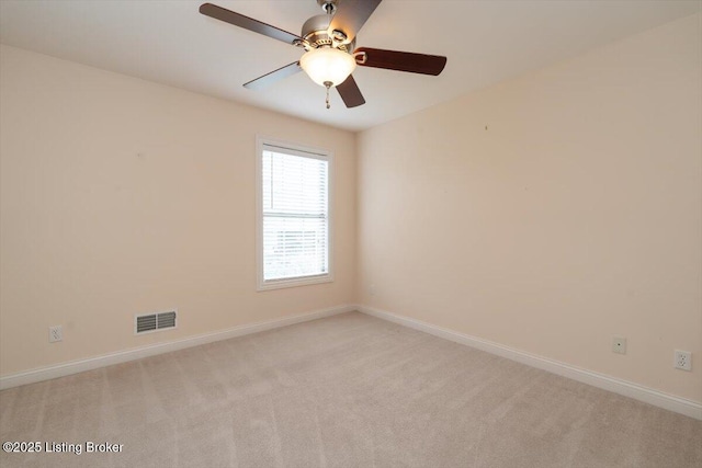 unfurnished room with visible vents, ceiling fan, light carpet, and baseboards