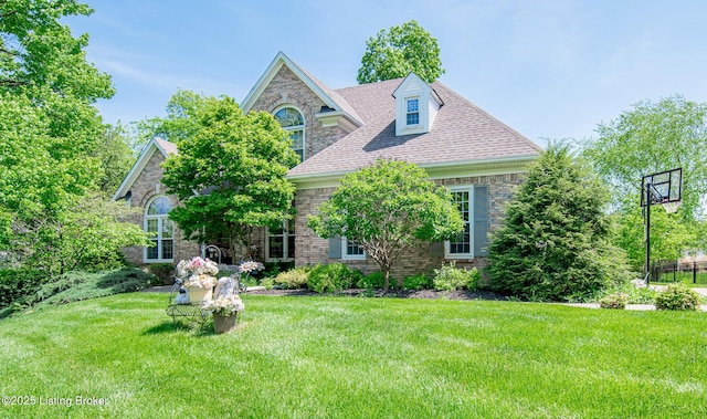 view of front facade with stone siding, roof with shingles, brick siding, and a front lawn