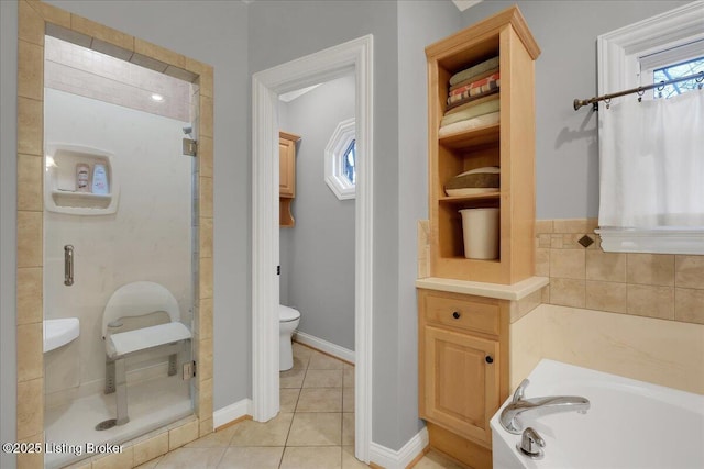 bathroom with a garden tub, toilet, baseboards, a shower stall, and tile patterned floors