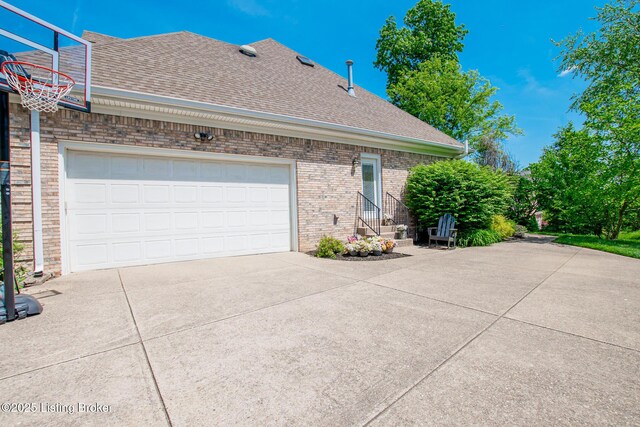 view of property exterior featuring a shingled roof, brick siding, and driveway