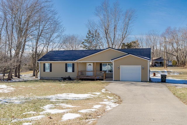 view of front of property featuring metal roof, an attached garage, covered porch, driveway, and crawl space