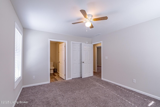 unfurnished bedroom with ensuite bath, carpet flooring, a ceiling fan, and baseboards