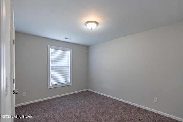 empty room featuring carpet flooring and baseboards