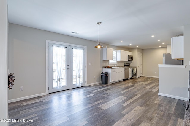 kitchen with stainless steel appliances, wood finished floors, baseboards, white cabinets, and french doors