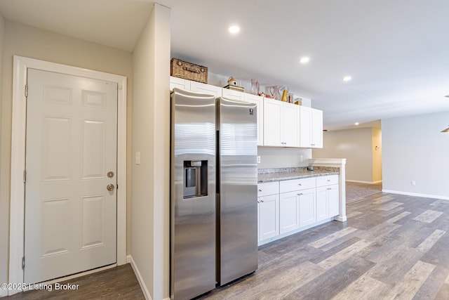 kitchen featuring recessed lighting, dark wood-type flooring, white cabinetry, baseboards, and stainless steel fridge