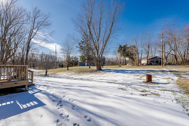 snowy yard featuring a wooden deck