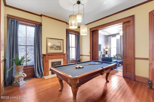 rec room featuring light wood finished floors, a fireplace with flush hearth, and a wealth of natural light