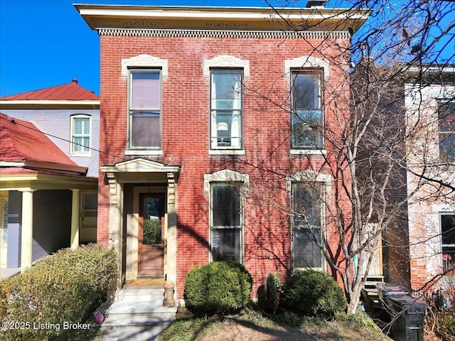 italianate home featuring brick siding