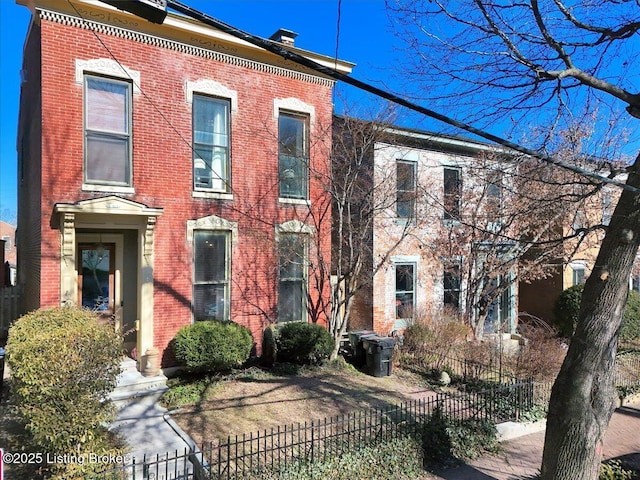 view of front of house featuring a fenced front yard and brick siding