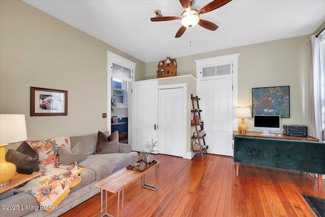 living area featuring a ceiling fan and hardwood / wood-style floors