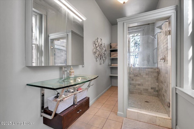 full bathroom featuring tile patterned flooring, a sink, a shower stall, and baseboards