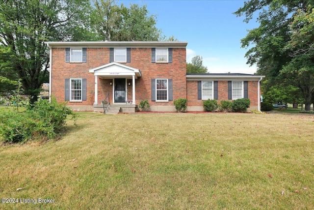 colonial-style house with brick siding and a front yard