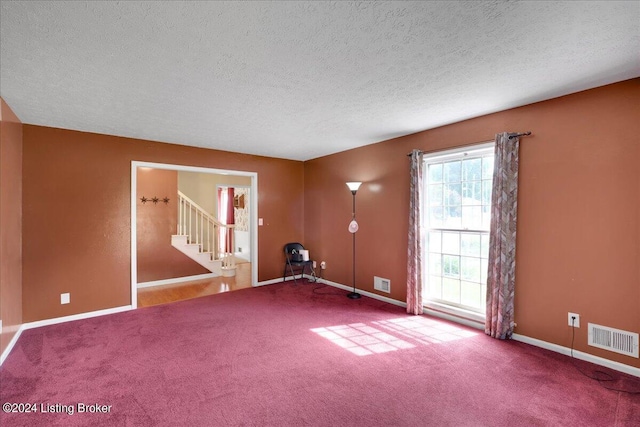 spare room featuring stairs, carpet, and visible vents