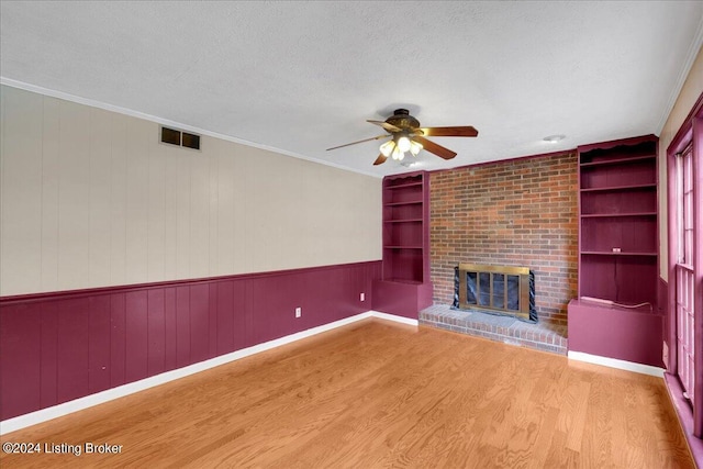 unfurnished living room with a textured ceiling, built in shelves, and visible vents