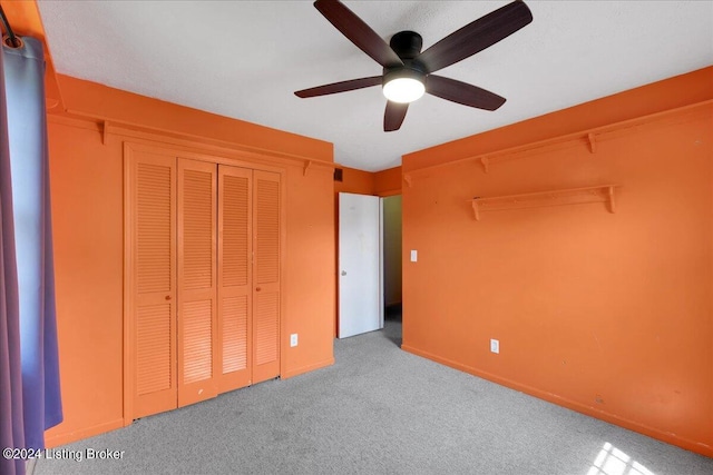 unfurnished bedroom with a closet, carpet flooring, and ceiling fan