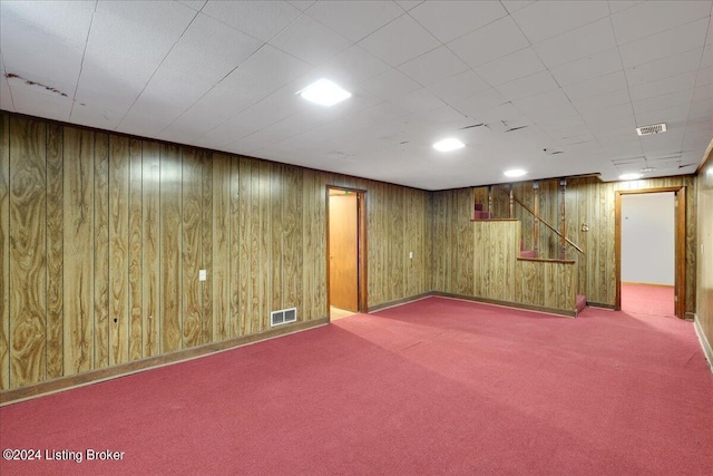 finished below grade area featuring carpet floors, visible vents, and wooden walls