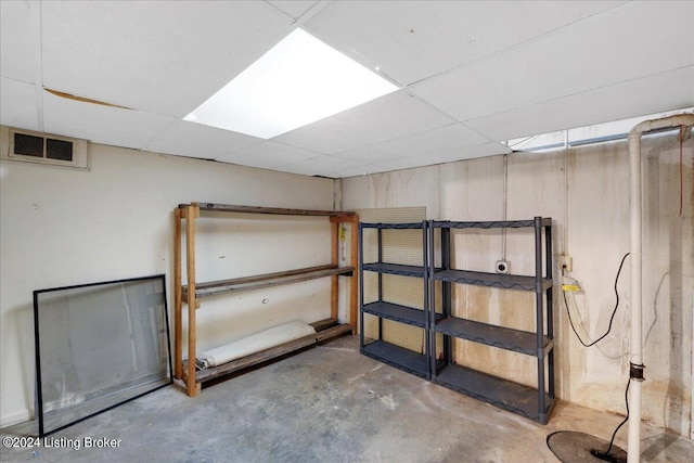 finished basement featuring a paneled ceiling and visible vents