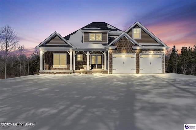 craftsman inspired home with driveway, covered porch, and brick siding