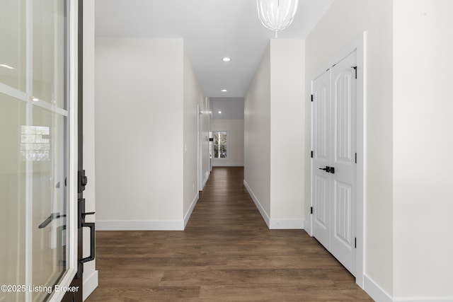 hall featuring recessed lighting, wood finished floors, and baseboards