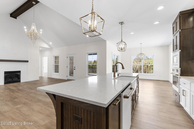 kitchen featuring light wood-type flooring, white appliances, and a notable chandelier