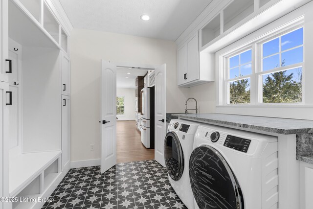 clothes washing area with cabinet space, recessed lighting, a wealth of natural light, and independent washer and dryer