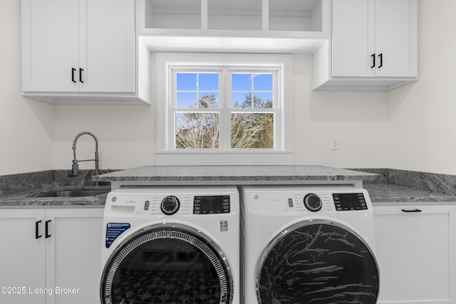 laundry room featuring cabinet space, a sink, and washing machine and clothes dryer