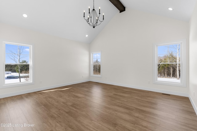 empty room featuring a chandelier, high vaulted ceiling, wood finished floors, baseboards, and beam ceiling