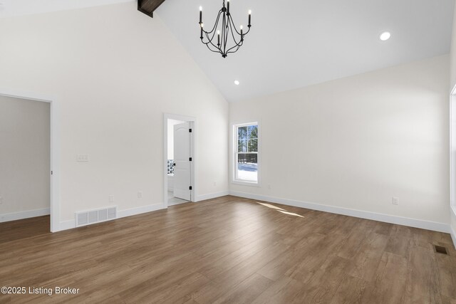 unfurnished room featuring high vaulted ceiling, wood finished floors, visible vents, baseboards, and beamed ceiling