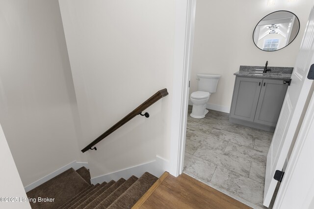 bathroom with baseboards, vanity, and toilet